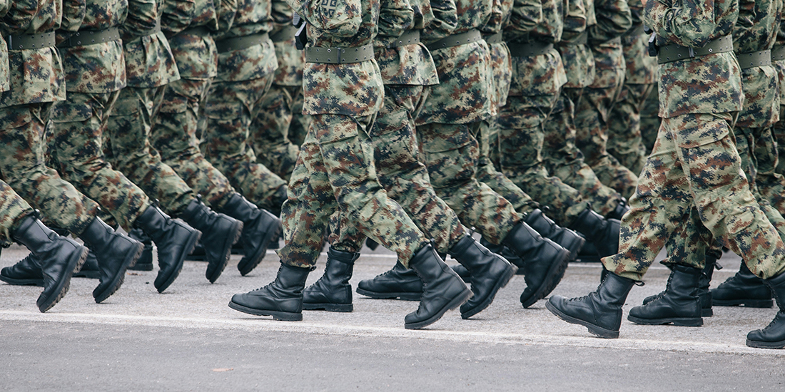 The feet of soldiers in army camouflage marching in formation