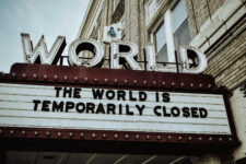 Outdoor theater sign that states "the world is temporarily closed"