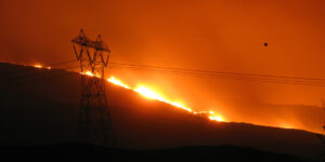 Fire on hillside behind power lines