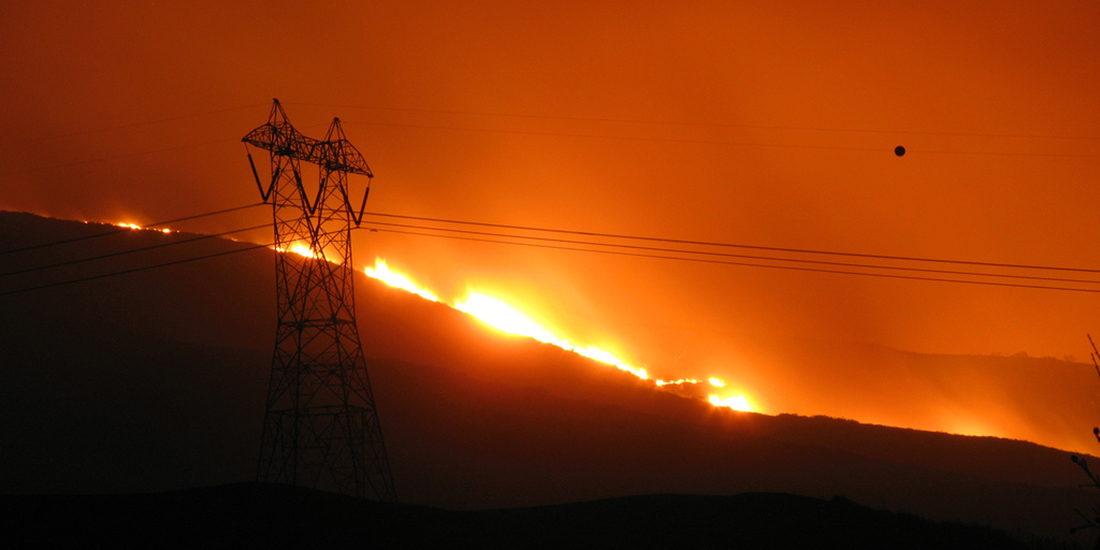 Fire on hillside behind power lines