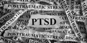 Torn pieces of paper with abbreviate PTSD. Posttraumatic stress disorder. Concept Image. Closeup.