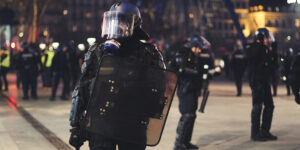 Law enforcement officers wearing riot gear and gas masks