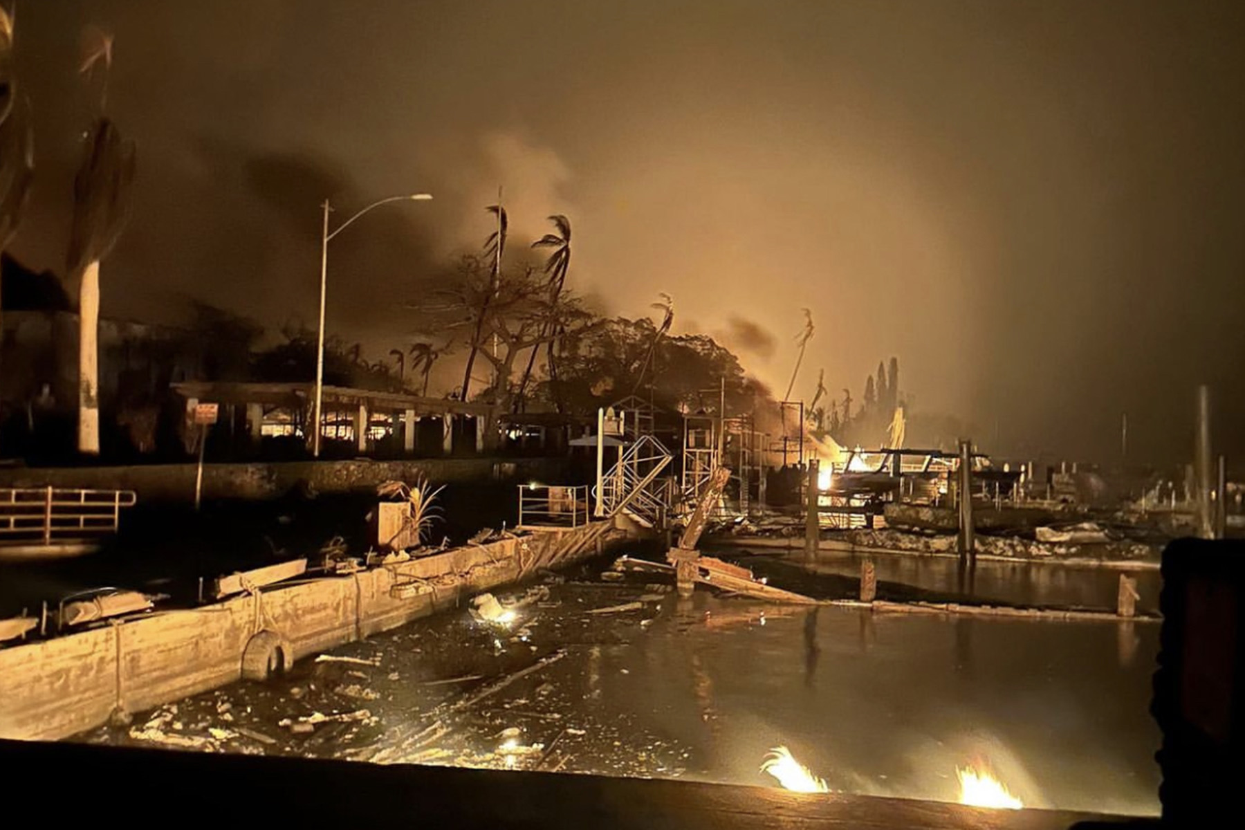 A boat harbor at night, sunken dock, and smoke-filled sky