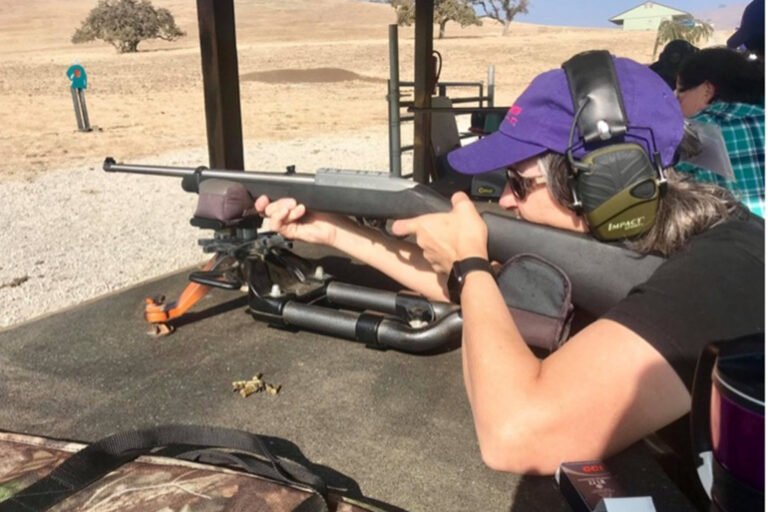 Woman holding a gun at a shooting range