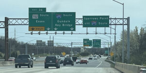 highway with automobiles under a sign that directs traffic to the Key Bridge