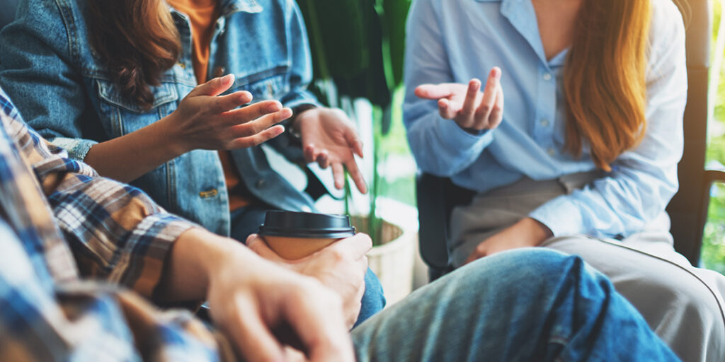 Three people sitting and talking together