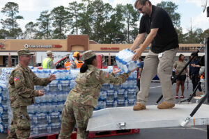 State Defense Forces: The Untapped Backbone of Emergency Response U.S. Army Soldiers with the Augusta-based 878th Engineer Battalion, 648th Maneuver Enhancement Brigade, Georgia Army National Guard, partner with Georgia State Defense Force personnel to unload cases of water during a point of distribution (POD) mission in Augusta, Georgia, Sept. 30, 2024. The Georgia National Guard has mobilized to provide response and recovery support to areas in the state impacted by Hurricane Helene. At the direction of the Governor and through The Georgia Emergency Management and Homeland Security Agency (GEMA/HS), the Georgia National Guard will continue to partner local, state, and federal entities in this effort. (U.S. Army National Guard photo by Spc. Ayanna Tillman)