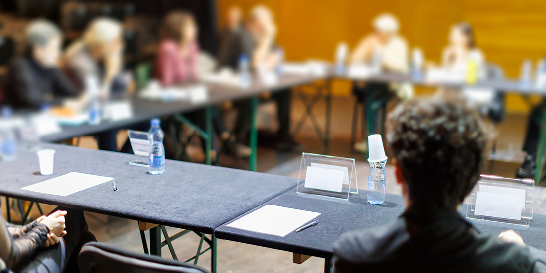 A group meets around a table for a collaborative discussion during an event in a community center setting.